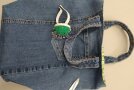 Tasche aus Jeansstoff, auf der kleines Kissen mit Stecknadeln liegt