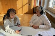 Zwei Frauen mit Kopfhörern und einem angeschlossenen Gerät