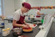Frau legt Erdbeeren auf Kuchenboden