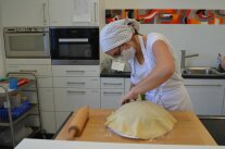 Frau drapiert Fondant auf Torte