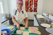 Person steht vor Platte mit Spargel