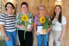 Vier Frauen stehen vor einer Holzwand