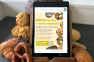 Tablet liegt auf Berg aus Semmeln, Brot und Brezeln