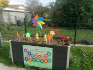 In einem Hochbeet stecken viele bunte Windräder