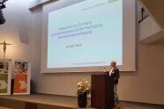 Michael Knickl steht am Rednerpult auf Bühne