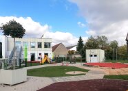 Vor dem Kindergartengebäude liegt ein großer Spielplatz.