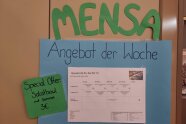 Das Angebot der Mensa wird auf einem großen Plakat beworben.