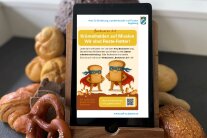 Tablet mit Wettbewerbsposter auf dem Bildschirm steht in Backwaren