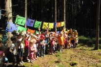 Kinder mit bunten Fahnen im Wald