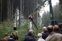 Gruppe Personen steht im Wald um eine Maschine herum