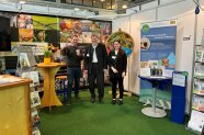 Drei Personen an einem Messestand