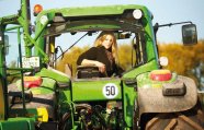 Frau sitzt auf grünem Traktor