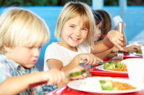 Kinder beim gemeinsamen Mittagessen in Mensa 